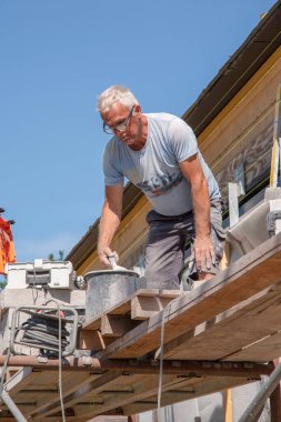 the bricklayer makes the facade of the house from gray bricks with cement and plaster at the construction site. High quality photo