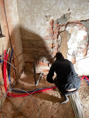 İnşaat alanında çalışan elektrikçi, bakım teknisyenleri eve elektrik tesisatı kuruyor. Yüksek kalite fotoğraf