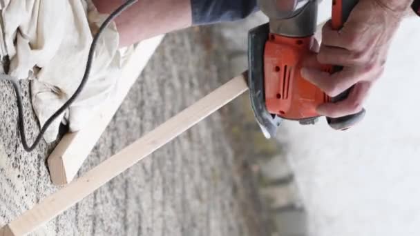 建筑工人用手工操作的砂纸电动磨床磨碎一块木头 近景加工木梁磨碎 高品质垂直4K镜头 — 图库视频影像