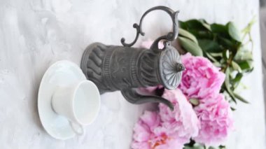 Hazır pudradan kahve yapan bir kadın, pembe şakayıklı bir fincan, koyu metalden kahve demliği olan bir hayat. Yüksek kalite 4k görüntü
