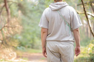 Ormanda bej rengi örgü elbiseli bir kadın günlük adımlarını atıyor, sağlıklı bir yaşam tarzı sürüyor, doğayla bütünleşmenin atmosferik destansı anı, bitki öldürücülerle dolu çam ormanındaki havayı soluyor.