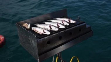 Teknede kızartılmış ızgara deniz balığı, Türkiye 'de tatil yapan turistler için en iyi akşam yemeğini hazırlayan denizciler, yüksek turizm hizmetleri, dalgalarda sallanan kayıklar,