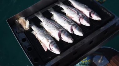 Teknede kızartılmış ızgara deniz balığı, Türkiye 'de tatil yapan turistler için en iyi akşam yemeğini hazırlayan denizciler, yüksek turizm hizmetleri, dalgalarda sallanan kayıklar,