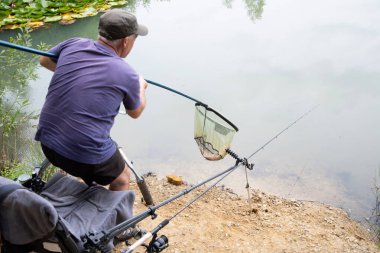 Başarılı balık avlama, gölde balık avlama, balık tutma, balık tutma gibi büyük ödülleri olan mutlu balıkçılar balığı yakaladıktan sonra balığı suya bırakıyor, kaliteli bir fotoğraf.