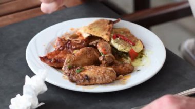 Masanın her yerinde çeşitli yemekler var. Otel restoranında, ızgara tavuk kanatları, etli Türk ekmeği, hırpalanmış balık, canınız ne isterse deneyebilirsiniz. 