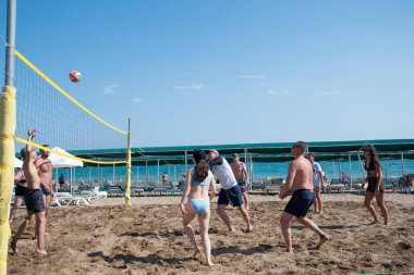Turistler tatil sırasında denizde plaj voleybolu oynarlar, 31 Mayıs 2024 'te Belek, Türkiye' deki Yeşil Max Oteli 'nin plajında dinlenirken açık mavi bir gökyüzünün arka planı.