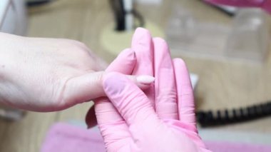Pembe koruyucu eldivenli manikürcü, saglik ve güzelligine özen gösteren, beyaz tenli bir kadinin saglik ve sagligina dikkat eden, saglikli,