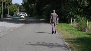 Modern mavi fiberglas alçıda sol bacağı kırık bir adam yürüme ayakkabıları serbestçe yürüyor dengesini korumadan, aktif rehabilitasyon konsepti