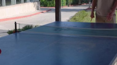 Sekiz yaşındaki sarışın çocuk babasıyla özel bir masa tenisi kortunda pinpon oynuyor çocuklar için eğlenceli yaz sporları, Türkiye 'deki tüm aileyle unutulmaz yaz tatilleri.