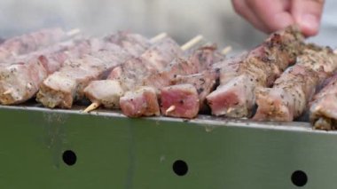 Kömürde et kebabı yapan genç bir adam, ARROSTICINI - tipik güney İtalyan mutfağı, yazın evin yakınındaki terasta lüks bir piknik, barbeküden aromatik dumanlar yükseliyor.,