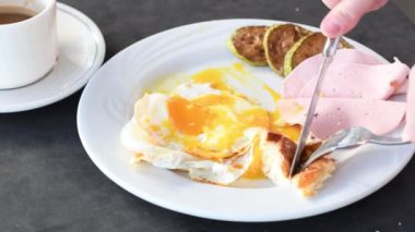 Tanımlanamayan kişi yaz tatillerinde otel restoranında çörekli kızarmış yumurta yiyor. Proteinli geleneksel İngiliz kahvaltısı, terasta güneşli bir gün.,