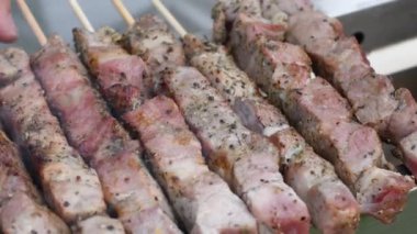 Kömürde et kebabı yapan genç bir adam, ARROSTICINI - tipik güney İtalyan mutfağı, yazın evin yakınındaki terasta lüks bir piknik, barbeküden aromatik dumanlar yükseliyor.,