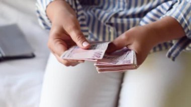 Kadın, önünde 200 lira banknot yığını tutuyor, bir vantilatörle yayıyor ve kameraya gösteriyor ki Türkiye 'de çok para ama çok az değer, çok az enflasyon var.
