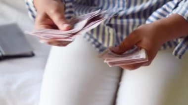 Kadın, önünde 200 lira banknot yığını tutuyor, bir vantilatörle yayıyor ve kameraya gösteriyor ki Türkiye 'de çok para ama çok az değer, çok az enflasyon var.
