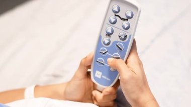 Hasta, konforlu bir dinlenme, iyileşme ve bakım konsepti bulmak için klinikteki yatağın başını kaldırma ve indirme düğmesine basıyor.,