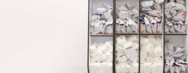 Birçok renkli sargı bezleri ve fiberglas bandajlar, hastane duvarındaki bir dolapta paketlerde, alçı odasının duvarında,