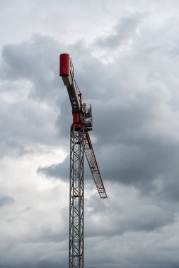 Gökyüzü bulutlu gökyüzüne karşı kırmızı çizgili kule vinç gerçekçi fotoğraf, kentsel yapı ve altyapı geliştirme konseptiyle yakalanmadan önce, boşluğu kopyala,
