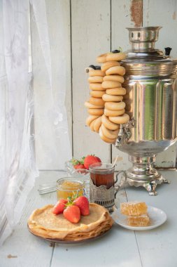 Maslenitsa için Rus geleneğinde hayat devam ediyor, ballı ve çilekli krep, simit dolu bir semaver çayı, Slav bayramı, yüksek kaliteli fotoğraf