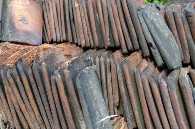 Eski kil kil kil çatı kiremitleri üst üste yığılmış. Değişen kahverengi, turuncu ve gri tonlarıyla ilginç bir soyut desen oluşturuyor. Doku ve hava durumunu gösteriyor.,