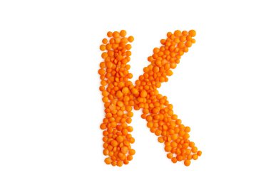 Kırmızı mercimek taneciklerinden oluşan büyük harf 'K' temiz beyaz zemin üzerinde. Organik elementler ve tipografinin uyumlu bir karışımı, çevre dostu vejetaryen sanatının özünü yakalar. Yemek blogu ve menüsü için mükemmel