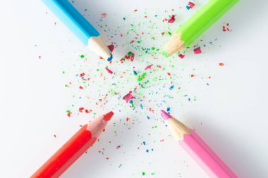 Renk senfonisi: beyaz arkaplanda talaş bulunan dört adet parlak desenli kalem.