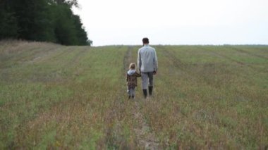 Baba ve kızı bir tarlada yürürken konuşuyor ve keşfediyor.