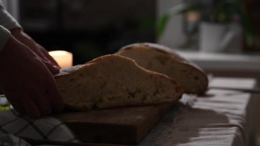 Baba ekmeği kırıyor ve kızına, ellerine ve ekmeğine uzatıyor..