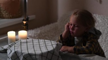 Kız gece üstü örtülü hamur kasesinin yanında oturur ve havlunun altına bakar..