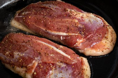 İki ördek göğsü, tuzlu ve biberli bir tavada kızartılır.