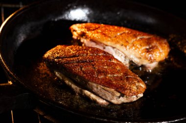 Fırında tavada iki pişmiş ördek göğsü ve altın bir kabuk.