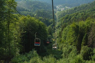 A cable car lift in the mountains in summer: a concept for travel, hiking, and ski tourism