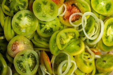 Taze dilimlenmiş yeşil domates, salata yapmaya hazır. Fotoğraf doğal, yumuşak ışıkta çekilmiştir..