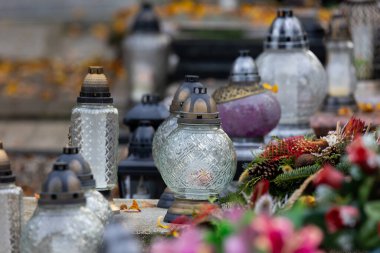 Azizler Günü 'nde mezarlıktaki mumlar ve çiçekler. Gündüz çekilmiş, doğal ışık..