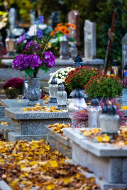 Azizler Günü 'nde mezarlıktaki mumlar ve çiçekler. Gündüz çekilmiş, doğal ışık..