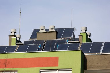Bir apartmanın çatısındaki güneş panelleri. Burada yaşayanlar için elektrik tasarrufu. Fotoğraf güneşli bir günde çekildi..