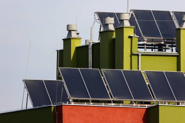 Bir apartmanın çatısındaki güneş panelleri. Burada yaşayanlar için elektrik tasarrufu. Fotoğraf güneşli bir günde çekildi..