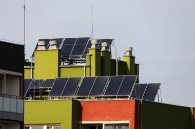 Bir apartmanın çatısındaki güneş panelleri. Burada yaşayanlar için elektrik tasarrufu. Fotoğraf güneşli bir günde çekildi..