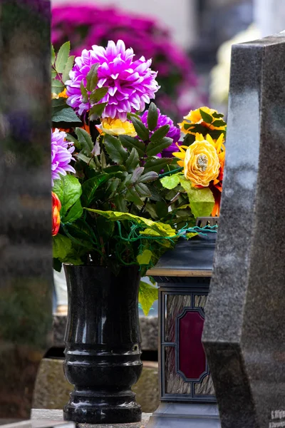 Flowers on graves in the cemetery during the All Saint's Day. Taken during the day, natual light.