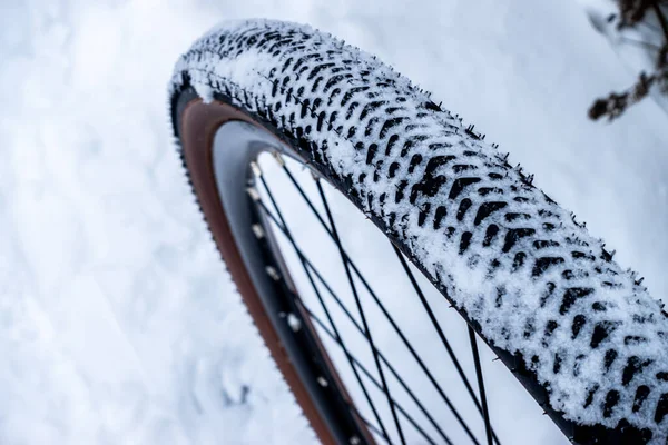 雪に覆われたトレイルで冬のライド中に雪で覆われた自転車のタイヤ ストックフォト