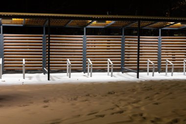 Kışın şehir parkında bisiklet rafları olan boş bir baraka. Kışın bisikletle seyahat etmenin zorlukları.