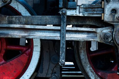 A close-up of a steam locomotive's propulsion system. Steam locomotive standing on the tracks, photo taken in natural lighting conditions.