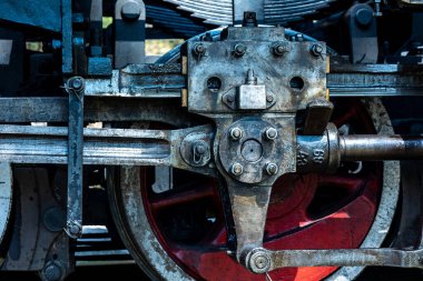 A close-up of a steam locomotive's propulsion system. Steam locomotive standing on the tracks, photo taken in natural lighting conditions.