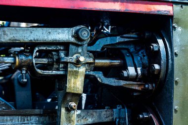A close-up of a steam locomotive's propulsion system. Steam locomotive standing on the tracks, photo taken in natural lighting conditions.