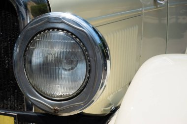 Round headlamp of an oldtimer car. Vehicles from the period before World War II