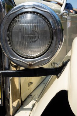 Round headlamp of an oldtimer car. Vehicles from the period before World War II