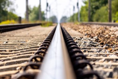 Railway track rails on a hot summer day. Super low angle perspective shot