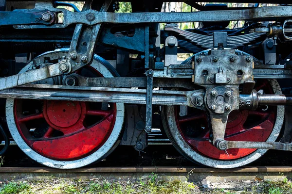 A close-up of a steam locomotive\'s propulsion system. Steam locomotive standing on the tracks, photo taken in natural lighting conditions.