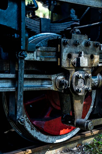 A close-up of a steam locomotive\'s propulsion system. Steam locomotive standing on the tracks, photo taken in natural lighting conditions.