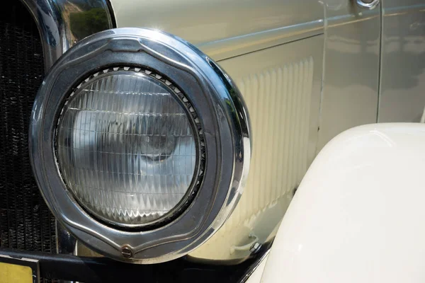 Round headlamp of an oldtimer car. Vehicles from the period before World War II