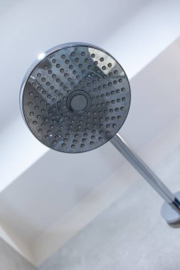 Duş başlığı duş tepsisinin duvarına sabitlendi. Yukarıdan banyoya püskürtülen bir duş.